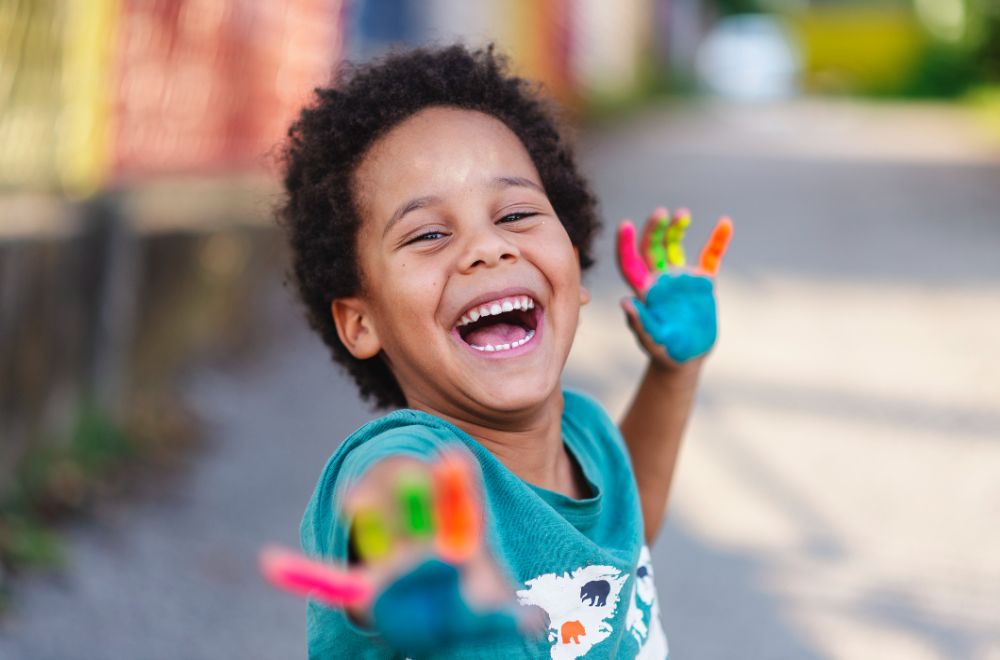 African American happy boy with painted hands